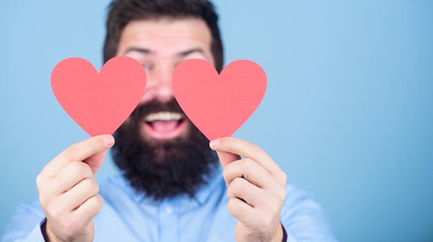 Concept de rencontres et de relations Heureux en amour L'amour est incroyable Hipster barbu homme avec carte de Saint Valentin coeur Célébrez l'amour Guy attrayant avec barbe et moustache dans une ambiance romantique Ressentir l'amour