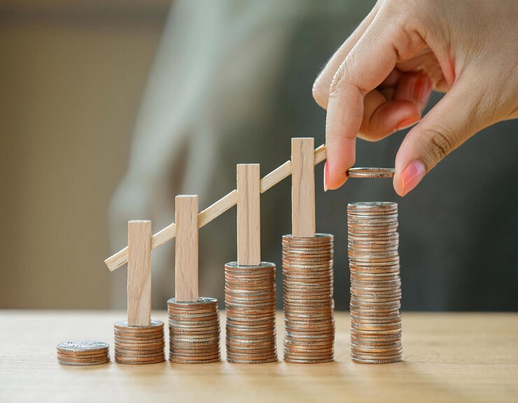 Photo concept de rendement sur l'investissement roi avec des visuels de pièces empilées et de petites figures en bois ambulantes