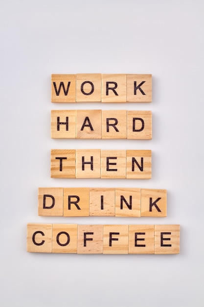 Concept de repos du travail. Travaillez dur puis buvez du café. Blocs en bois isolés sur fond blanc.