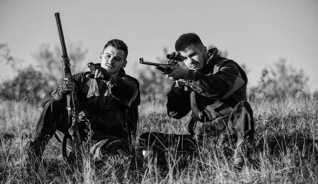 Concept de repos pour les vrais hommes Discuter de la capture Chasseurs avec des fusils se détendre dans l'environnement naturel Ami chasseur profiter des loisirs sur le terrain Chasser avec des amis passe-temps loisirs Chasseurs gardes-chasse se détendre