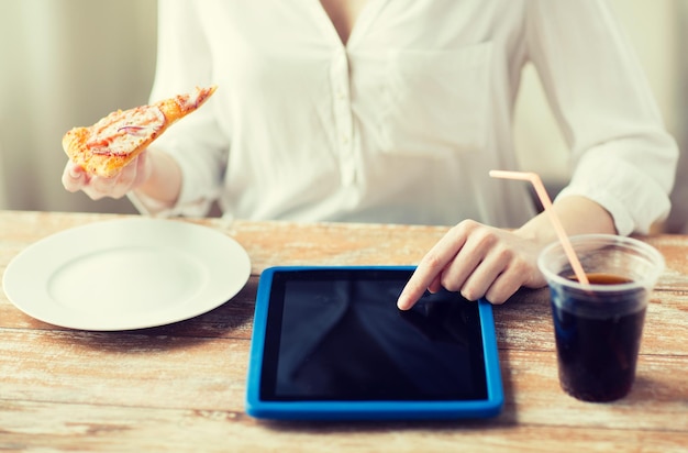 concept de restauration rapide, de personnes, de technologie et de régime alimentaire - gros plan sur des mains de femme avec ordinateur tablette, pizza et coca cola comptant les calories à table