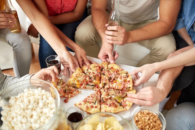 concept de restauration rapide, de restauration, de fête et de personnes - gros plan de personnes prenant des tranches de pizza à la maison