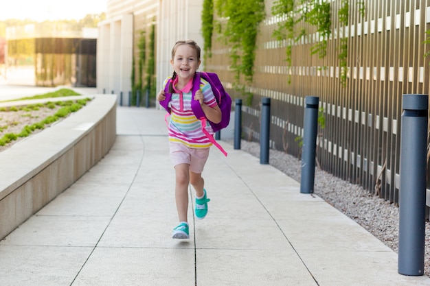 concept de retour à l'école. Premier jour d'école. Fille heureuse enfant court en classe.