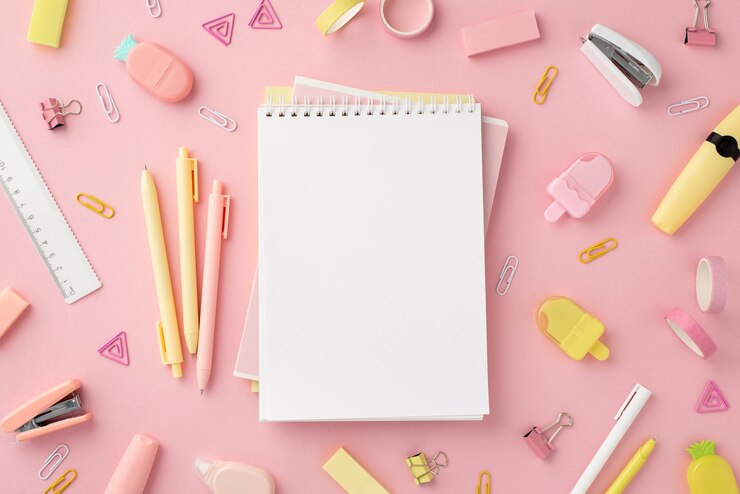 Concept de retour à l'école Vue de dessus photo de blocs-notes stylos taille-crayons en forme de crème glacée agrafeuses règle clips marqueurs de ruban adhésif et gommes en forme d'ananas sur fond rose isolé avec fond