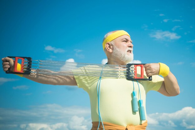 Concept de retraite de liberté de style de vie gai de santé homme âgé pratiquant des sports sur le ciel bleu b...