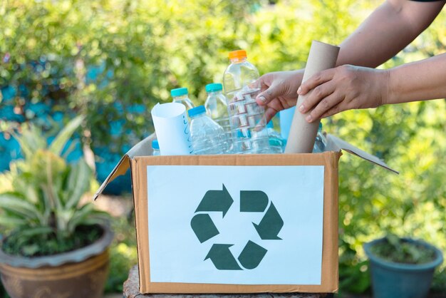 Le concept de réutilisation des déchets de bouteilles en plastique pour le recyclage Les bénévoles stockent des bouteelles en plastique dans des boîtes en carton dans un parc L'élimination, le recycle et la gestion des déchets Une bonne conscience