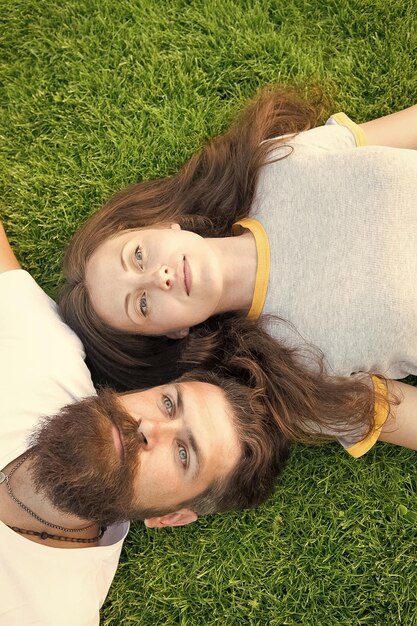 Concept de rêve Rencontre hipster barbu et fille insouciante Jeunesse et liberté Plus près de la nature couple se sentir libre couple allongé sur l'herbe verte homme et femme se détendre en plein air Couple amoureux se détendre prairie