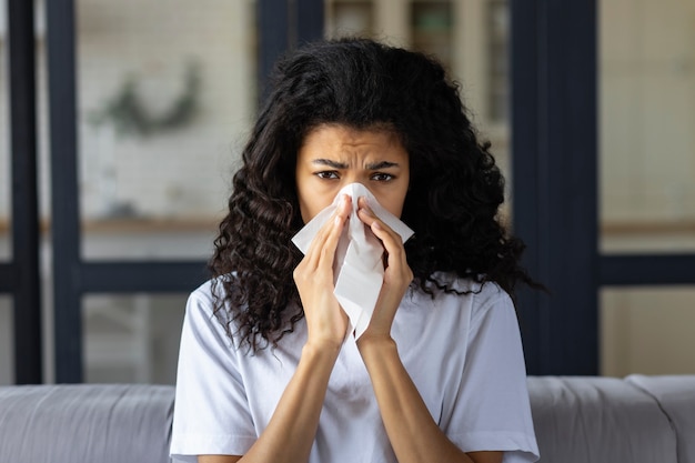 Photo concept de rhume et de grippe. jeune femme afro-américaine avec le froid, les éternuements et l'utilisation d'une serviette