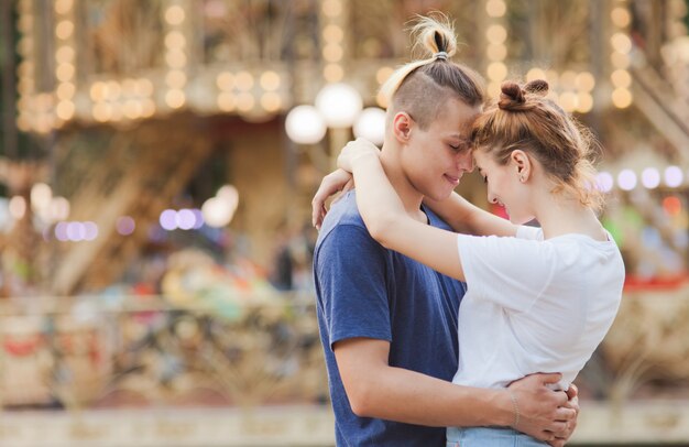 Concept romantique. Beau jeune couple amoureux s'amuser au parc d'attractions.