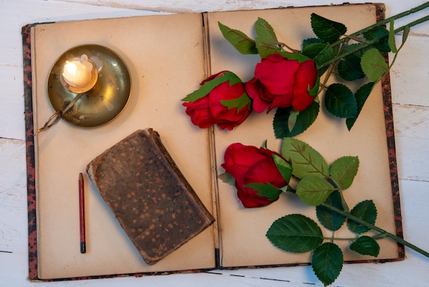 Concept romantique, vieux carnet, roses et petite bougie