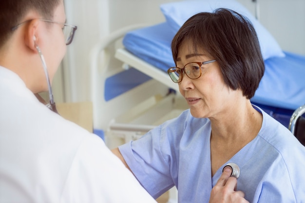 Photo concept sain; médecin vérifiant le coeur du patient avec stéthoscope à l'hôpital