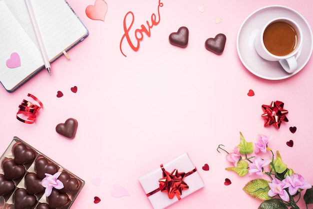 Concept de la Saint-Valentin. Bonbons au chocolat et café, coeurs sur fond rose. Espace de copie plat. Carte de voeux et cadeau.