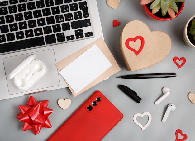 Concept de la Saint-Valentin avec des gadgets modernes et vue de dessus de carte vierge sur table grise