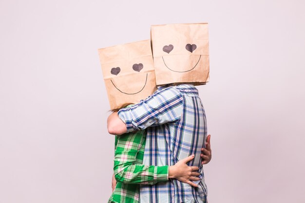 Concept de la Saint-Valentin - Jeune couple amoureux avec des sacs sur la tête sur fond blanc