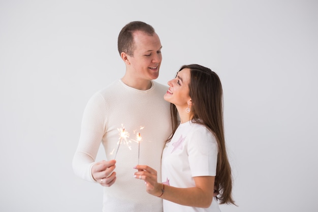 Concept de la Saint-Valentin jeune heureux souriant joyeux couple attrayant célébrant avec des cierges magiques sur