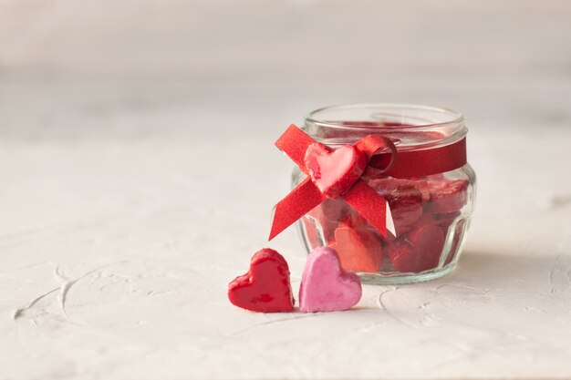 Concept de la Saint-Valentin. pot à petits coeurs rouge et rose sur un fond clair.