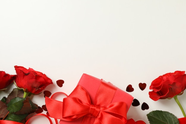 Concept de la Saint-Valentin avec des roses et une boîte-cadeau sur fond blanc