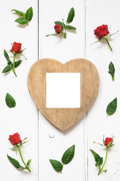 Concept de la Saint-Valentin roses rouges et coeur en bois sur fond blanc