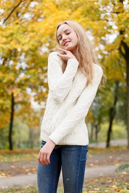 Concept de saison et de personnes - belle jeune femme heureuse s'amusant avec des feuilles dans le parc d'automne