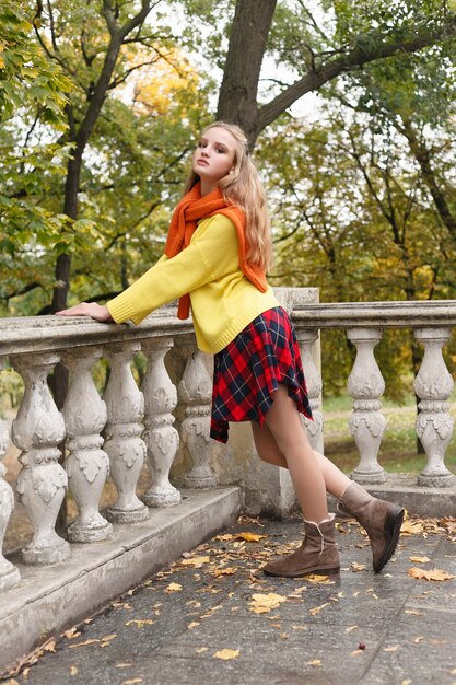 Concept de saison et de personnes - belle jeune femme heureuse s'amusant avec des feuilles dans le parc d'automne