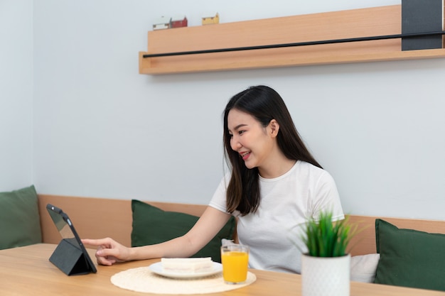 Concept de salon une femme utilisant son appareil électronique pour travailler à distance dans la salle confortable du café.