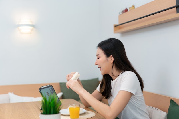 Concept de salon une femme utilisant son appareil électronique pour travailler à distance dans la salle confortable du café.