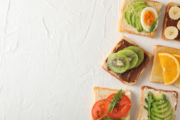 Concept avec des sandwichs assortis sur fond blanc, vue de dessus