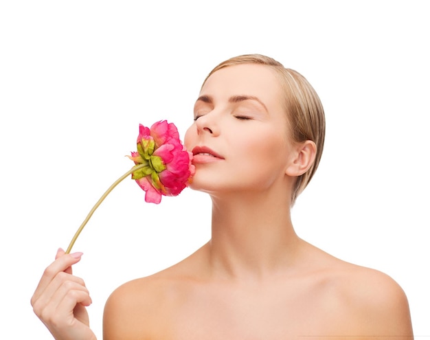 concept de santé et de beauté - belle femme avec fleur de pivoine rose et yeux fermés