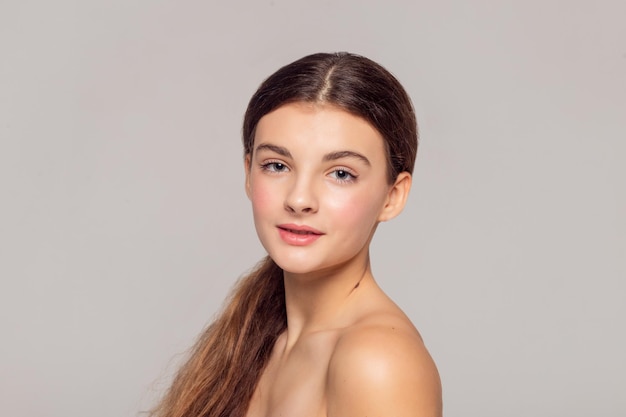 Concept de santé et de beauté - Belle jeune femme avec une peau propre et fraîche touche son propre visage. Traitement facial . Cosmétologie , beauté et spa .