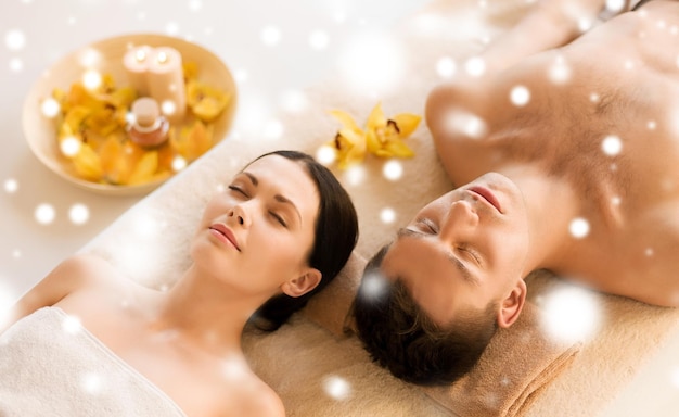 concept de santé et de beauté - couple dans un salon spa allongé sur les tables de massage