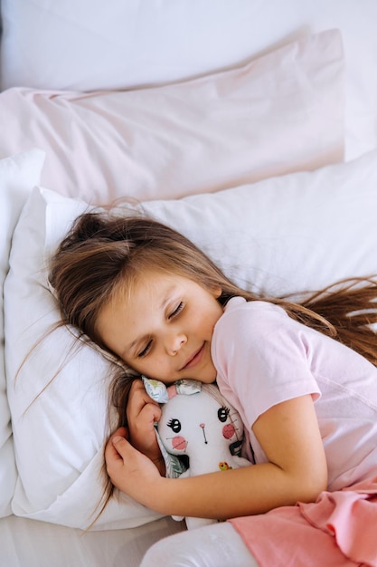 Concept de santé et de beauté petite fille avec jouet dormant à la maison