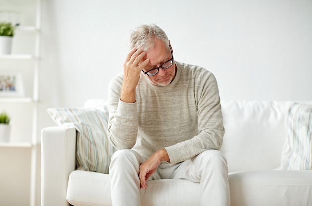 concept de santé, de douleur, de stress, de vieillesse et de personnes - homme âgé souffrant de maux de tête à la maison