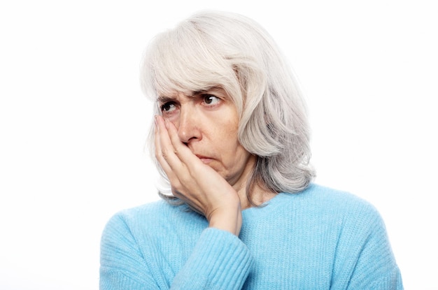 Concept de santé et de personnes de style de vie Femme âgée souffrant de maux de dents sur fond blanc