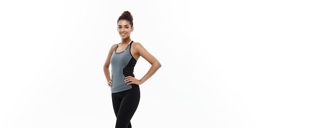 Concept de santé et de remise en forme portrait d'une fille afro-américaine posant avec des vêtements de fitness sur fond de studio blanc