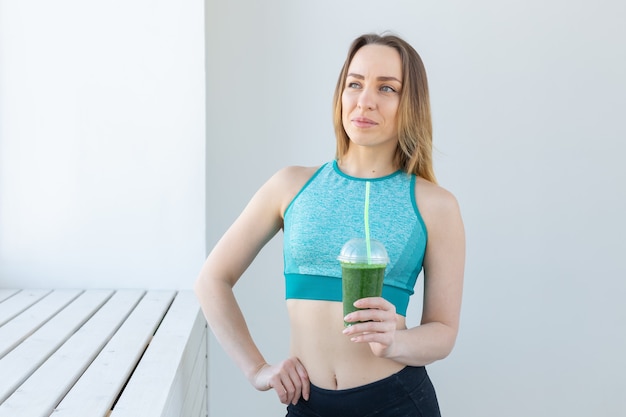 Concept de santé, de sport, de régime et de personnes - Femme urbaine de remise en forme réussie recommandant un smoothie de désintoxication