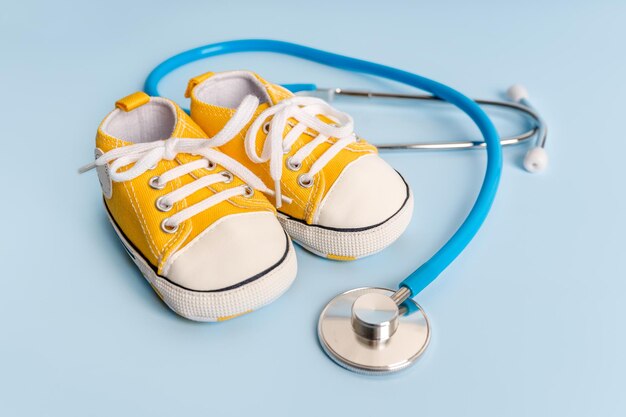 Le concept de santé et de traitement des enfants Chaussures pour enfants avec stéthoscope Place pour le texte