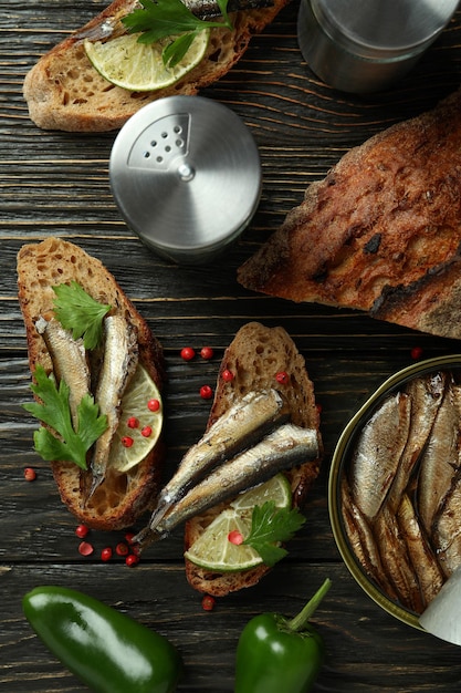 Concept de savoureuse collation avec des sandwichs aux sprats sur fond de bois