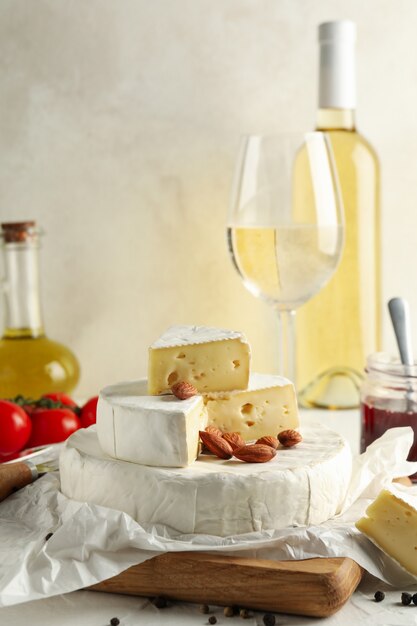 Concept de savoureux repas avec camembert, noisette et vin sur tableau blanc