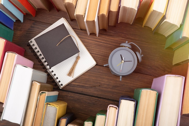 Concept de science de l'amour Forme de coeur de livres diplômé cap et horloge sur un bureau en bois Il est temps de prendre un diplôme en sciences naturelles