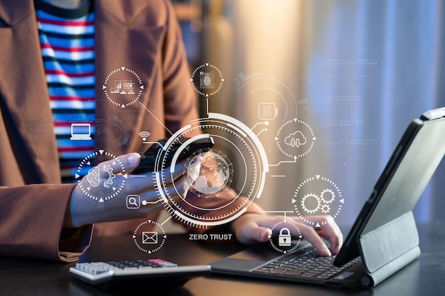 Concept de sécurité à confiance zéro Personne utilisant un ordinateur et une tablette avec une icône de confiance zéro sur l'écran virtuel des entreprises de données au bureau