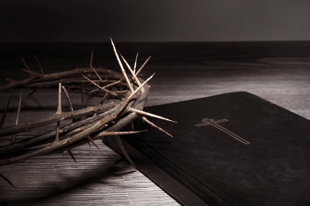 concept de la semaine sainte. couronne d'épines dans la lumière crue et la Bible repose sur la table. Contraste élevé.