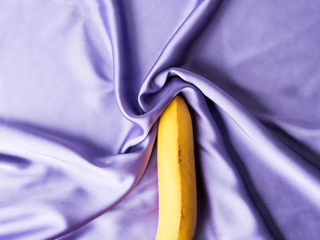 Photo concept de sexe et d'orgasme avec banane sur feuille de soie froissée