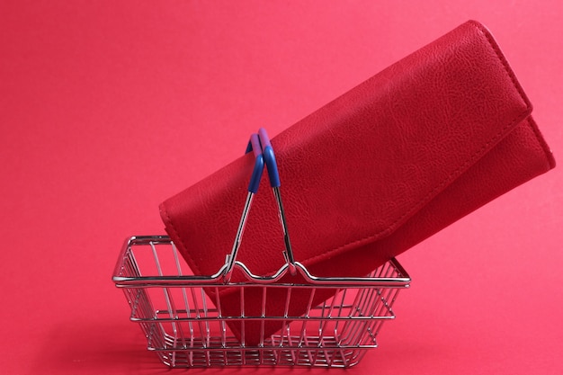 Photo concept de shopping minimaliste mini panier et portefeuille en cuir rouge