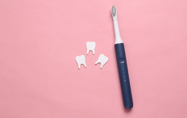 Concept de soins dentaires Brosse à dents avec dents sur fond rose Vue de dessus Mise à plat
