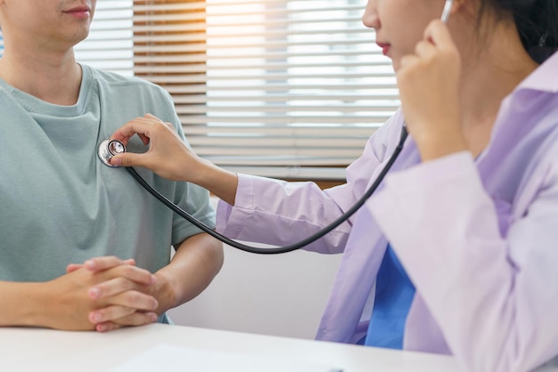 Concept de soins de santé Femme médecin utilisant un stéthoscope avec un patient pour examiner la fréquence pulmonaire et cardiaque