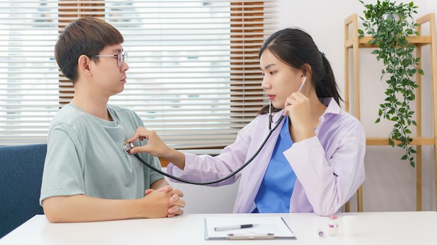 Concept de soins de santé Femme médecin utilisant un stéthoscope avec un patient pour examiner la fréquence pulmonaire et cardiaque