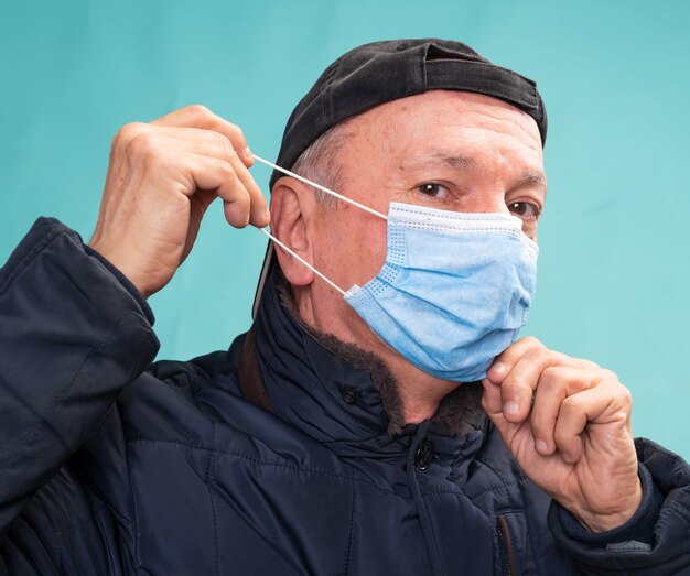 Concept de soins de santé. Man in masque de protection qui pose en studio sur fond bleu