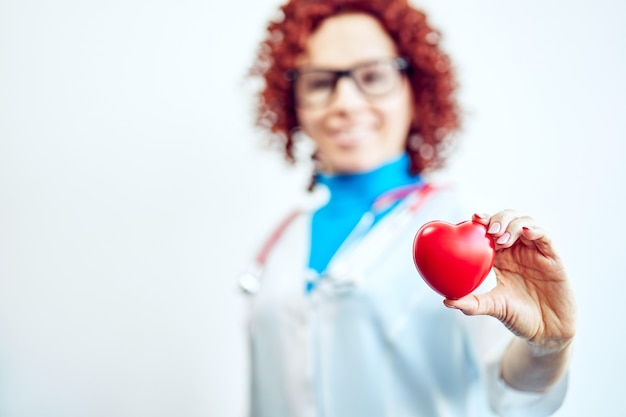 Photo concept de soins de santé, médecin avec un cœur dans les mains dans un hôpital.