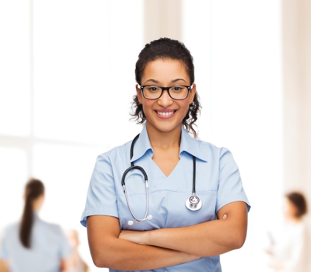 concept de soins de santé et de médecine - femme médecin ou infirmière afro-américaine souriante à lunettes avec stéthoscope