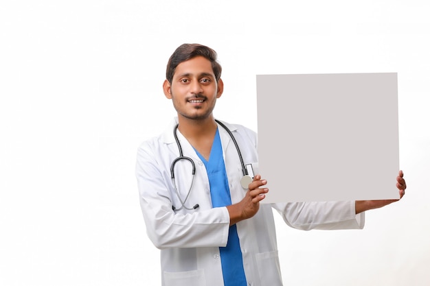 Concept de soins de santé, de profession et de médecine - Jeune médecin indien en uniforme avec planche sur fond blanc.